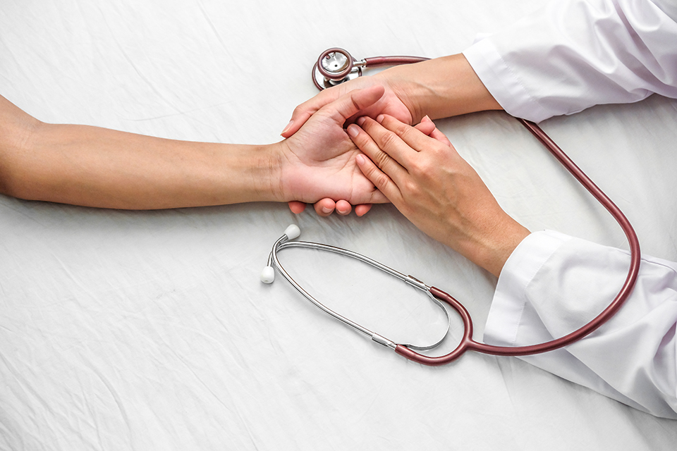 Hand of doctor reassuring her female patient Hand of doctor reassuring her female patient